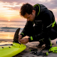 Jet ski rider adjusting surf fin on watercraft