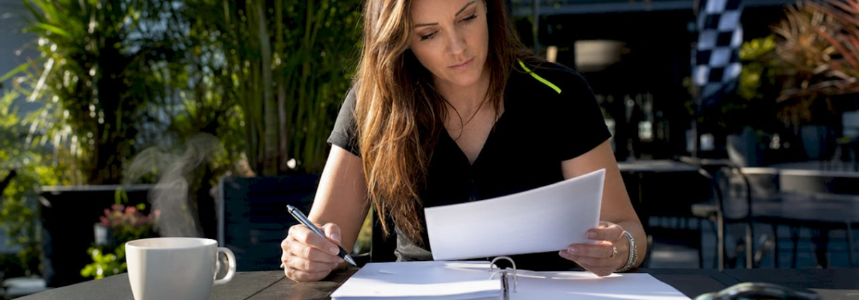 Woman reviewing PWC sponsorship application at desk