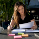 Woman reviewing PWC sponsorship application at desk