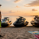 Man examining various personal watercraft types by dock