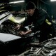 Technician tuning jet ski engine in workshop