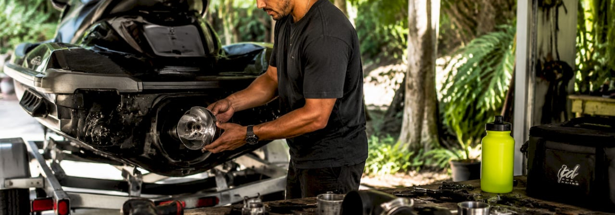 Mechanic installing jet ski modification parts