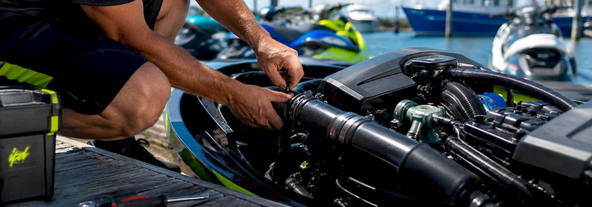 Mechanic installing jet ski cooling hose
