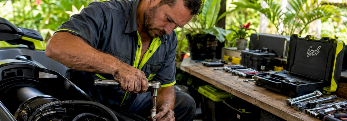 Mechanic removing spark plug from watercraft engine