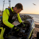 PWC racer inspecting watercraft on lakeside dock