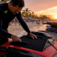 Man applying grip tape on jet ski deck at marina