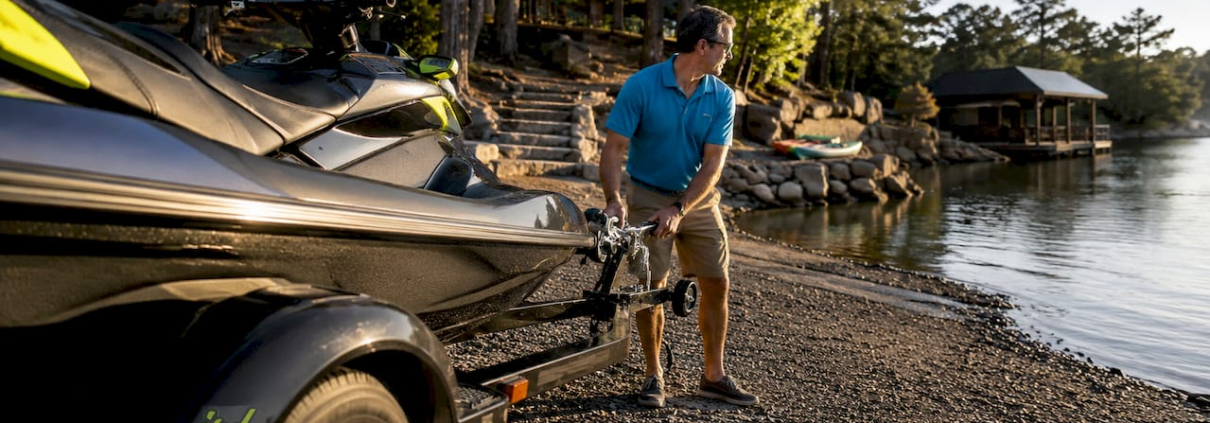 Man backing jet ski trailer on launch ramp