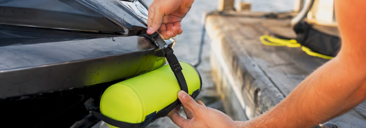 Hands attaching PWC dock bumper on hull