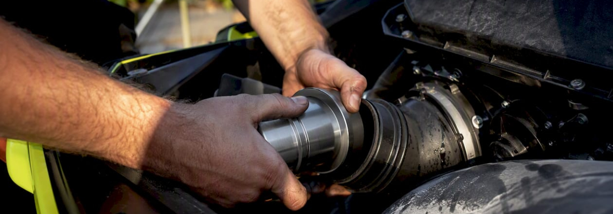 Hands installing blowback reducer in PWC exhaust