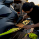 Hands applying vinyl wrap on jet ski hull