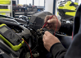Hands testing PWC starter solenoid with multimeter