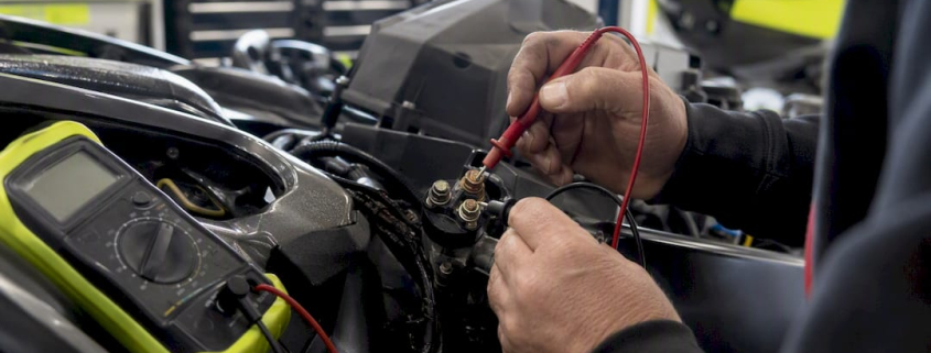 Hands testing PWC starter solenoid with multimeter