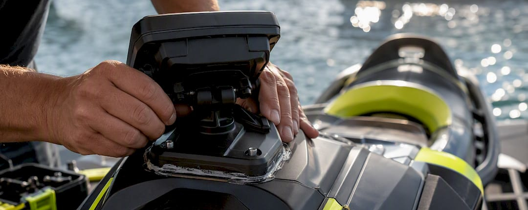 Hands installing rigid GPS mount on PWC cowling