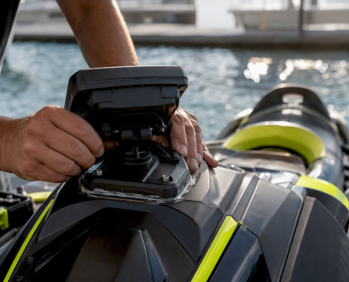 Hands installing rigid GPS mount on PWC cowling