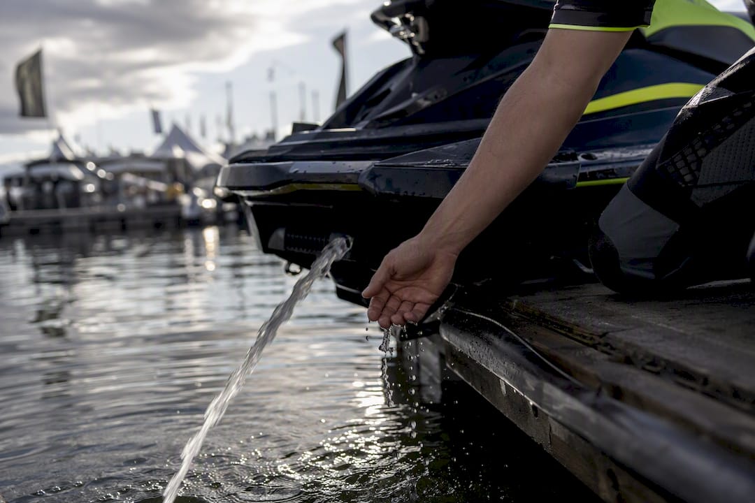 Hand checking water flow from jet ski pisser stream